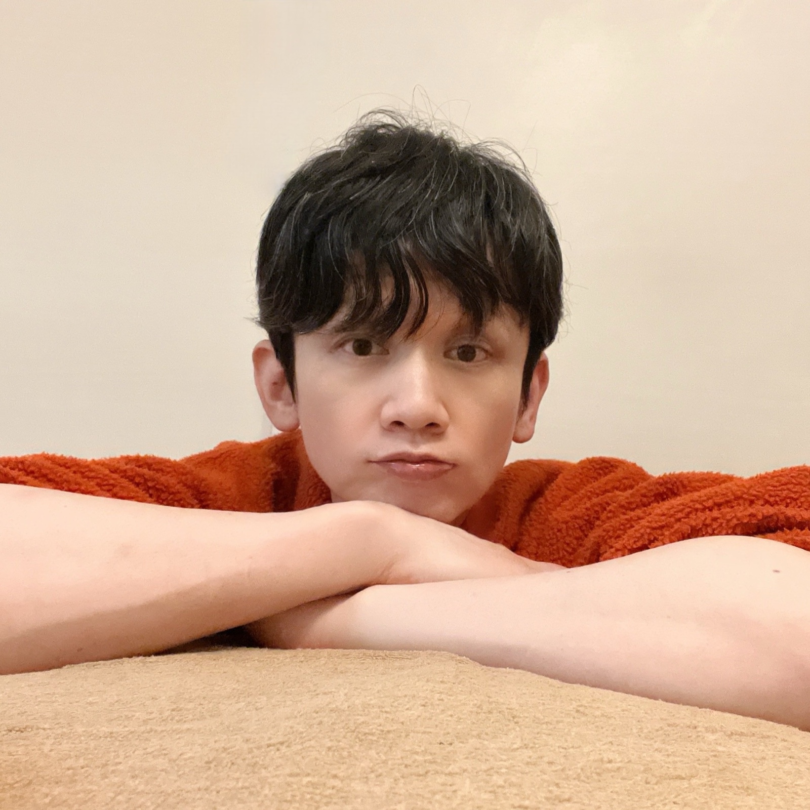 ムーンテッド(MoonTed)の日記より、施術台に腕を組んで、あごをのせるムーンテッド(MoonTed)のセラピストAKI。オレンジのセーター姿