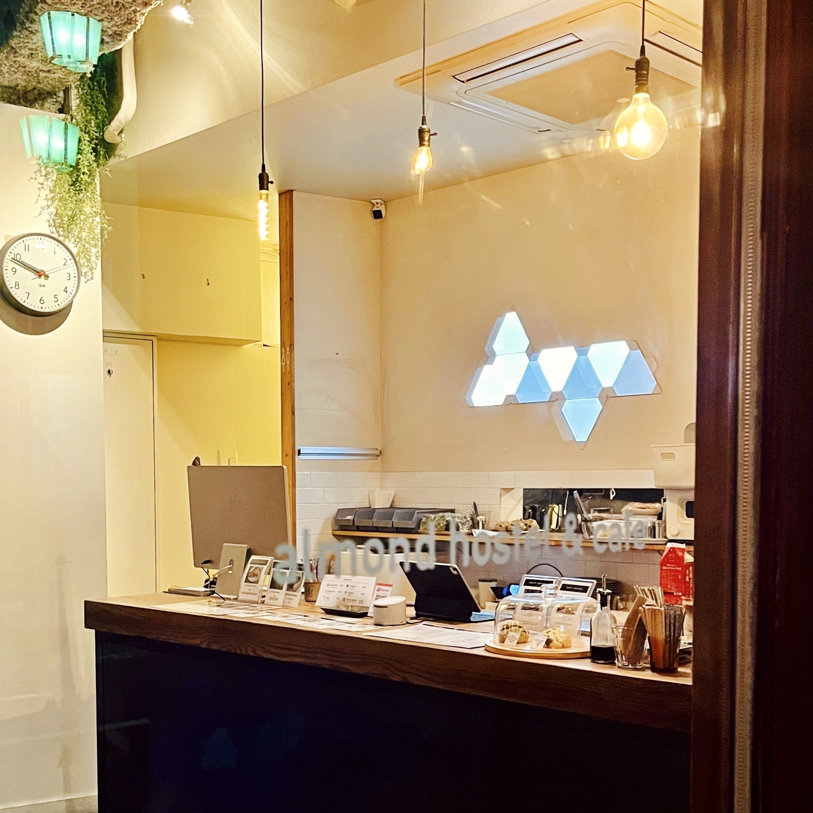 MoonTed Diary: The counter at almond hostel & cafe, with a hexagonal light fixture and bare-bulb pendant lights
