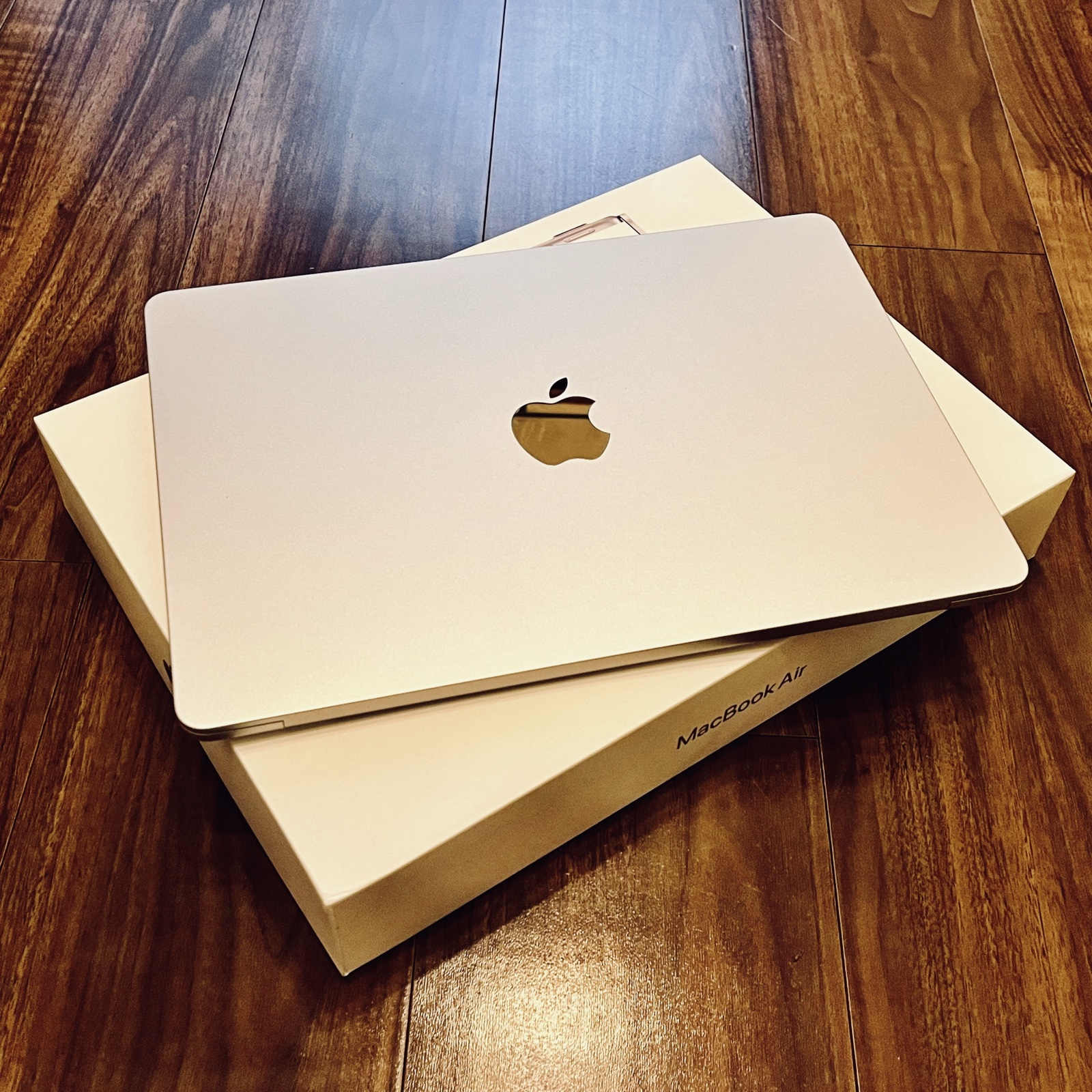 ムーンテッド(MoonTed)の日記より、箱の上に置いた新品のMacBook Air。木の床の上
