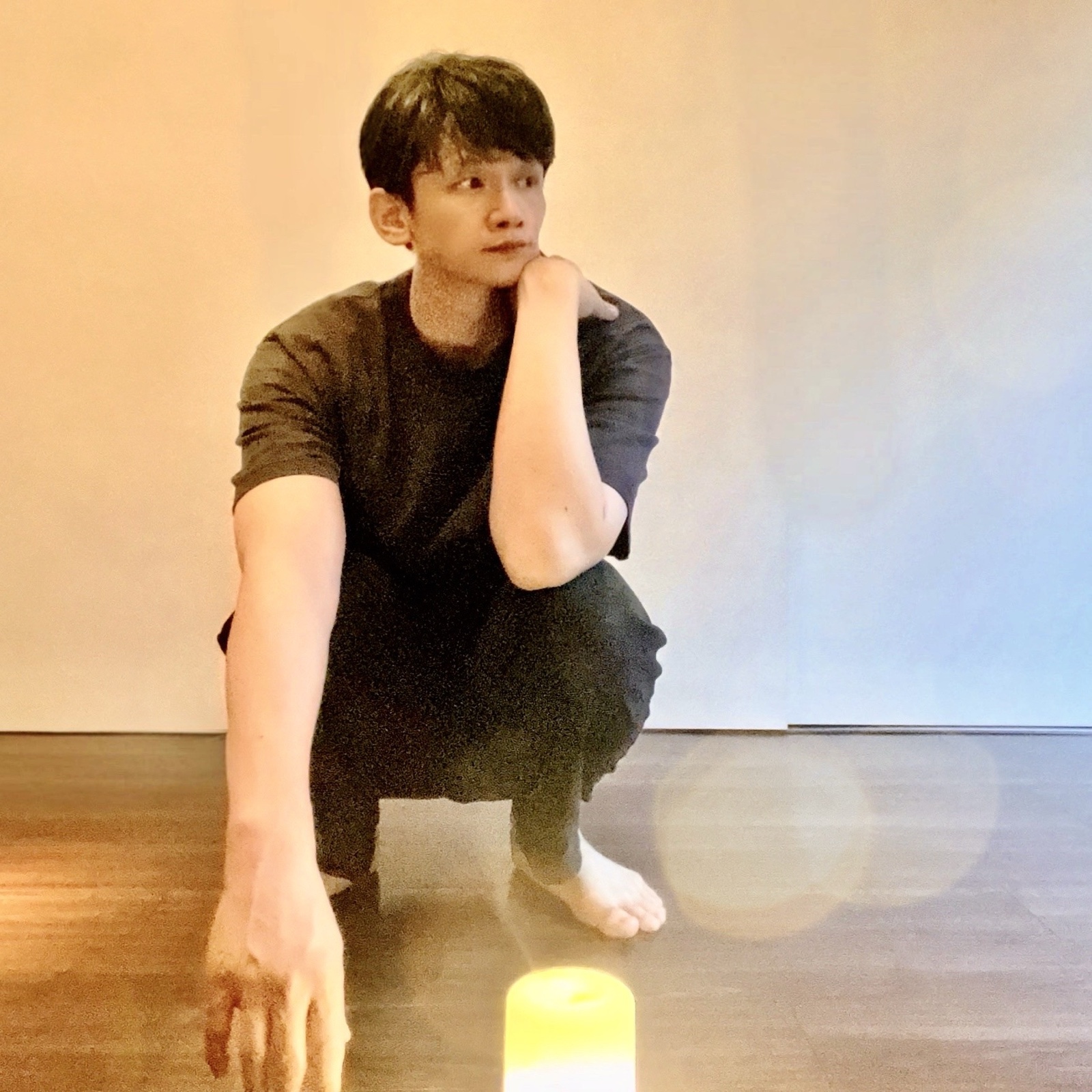 ムーンテッド(MoonTed)の日記より、素足でしゃがみ、頬杖をついて横を見るムーンテッド(MoonTed)のセラピストAKI。手前にキャンドルの灯り