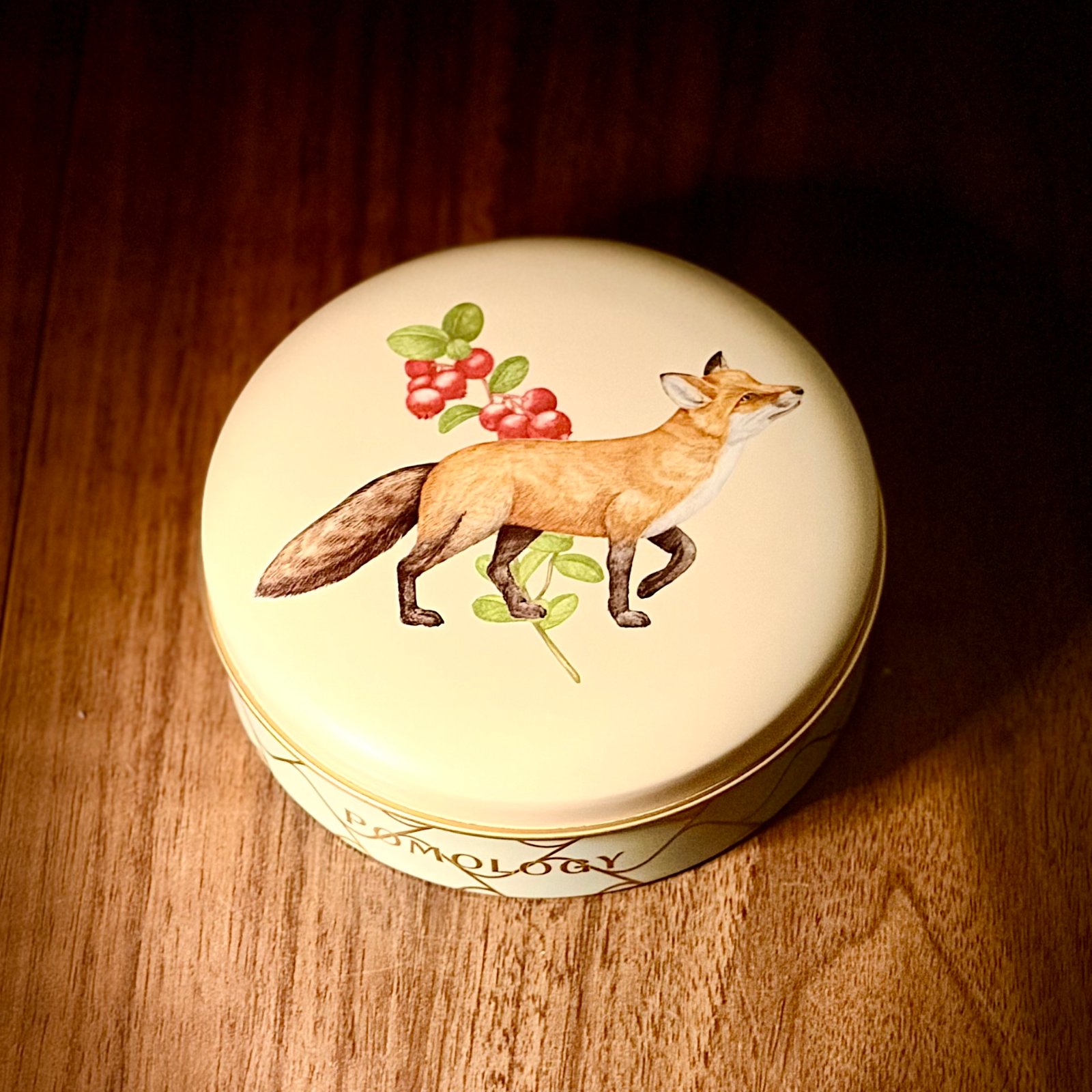ムーンテッド（MoonTed）の日記より、POMOLOGYのクッキー缶。クリーム色の蓋に、コケモモの実と歩く狐が描かれている