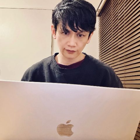 MoonTed Diary: Therapist AKI looking at a MacBook screen in a room with wooden blinds