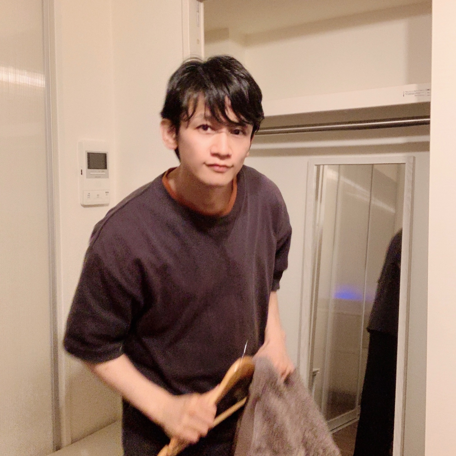 ムーンテッド（MoonTed）の日記より、ハンガーとタオルを手にするムーンテッド（MoonTed）のセラピストAKI。こげ茶のTシャツ姿