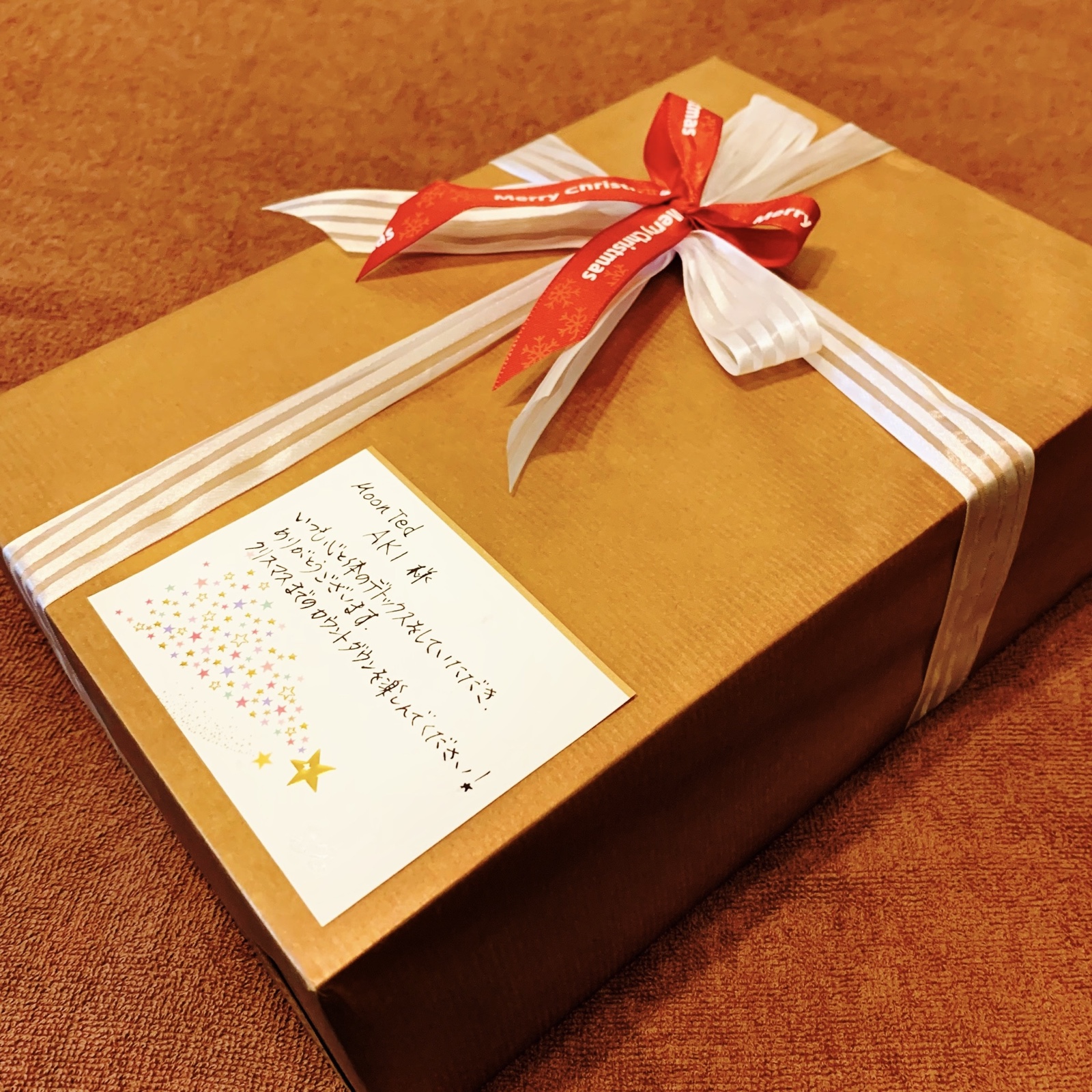 ムーンテッド（MoonTed）の日記より、リボンを掛けたクリスマスの贈り物の箱と、手書きのメッセージカード