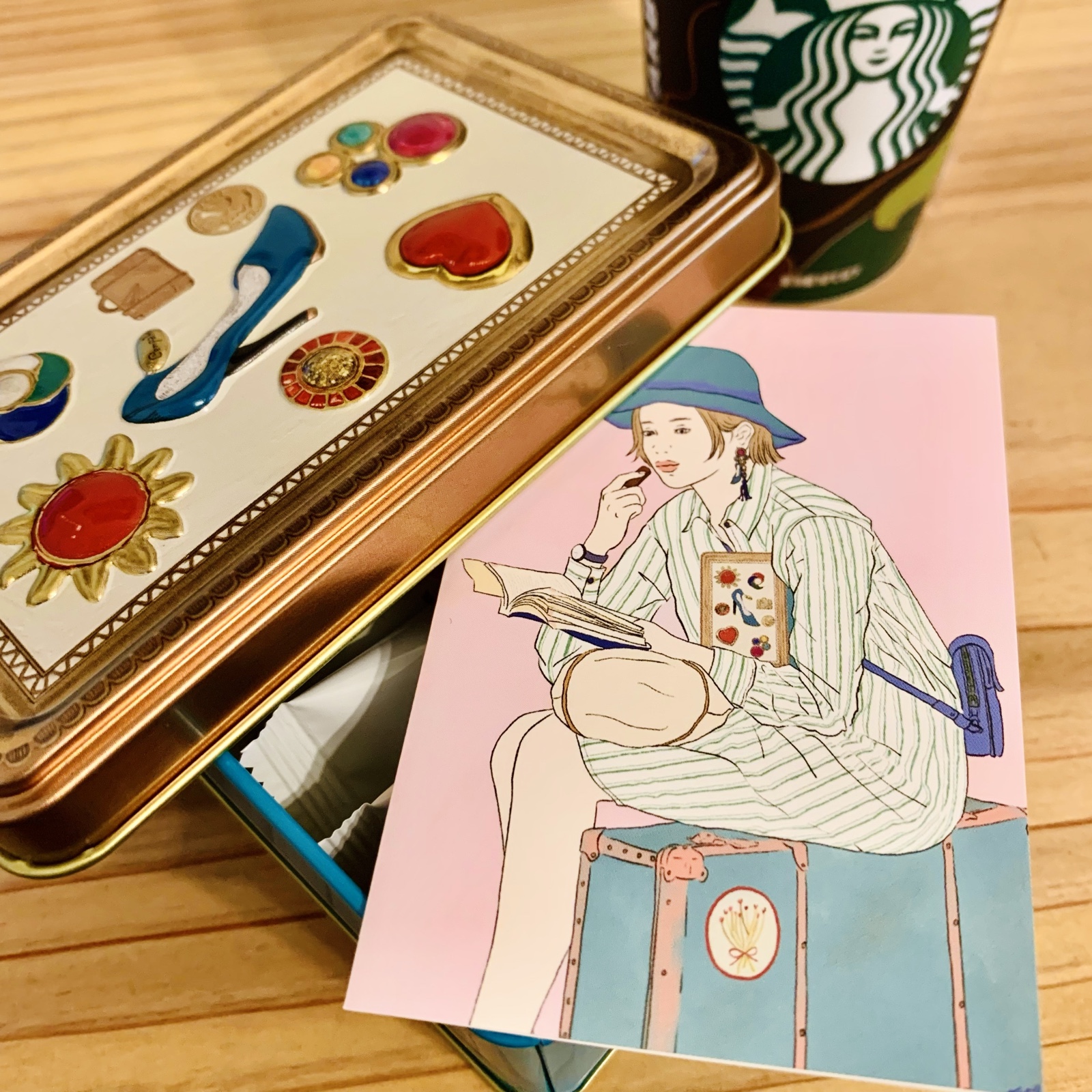 ムーンテッド（MoonTed）の日記より、缶に入っていたイラストのカード。トランクに座って本を読む女性