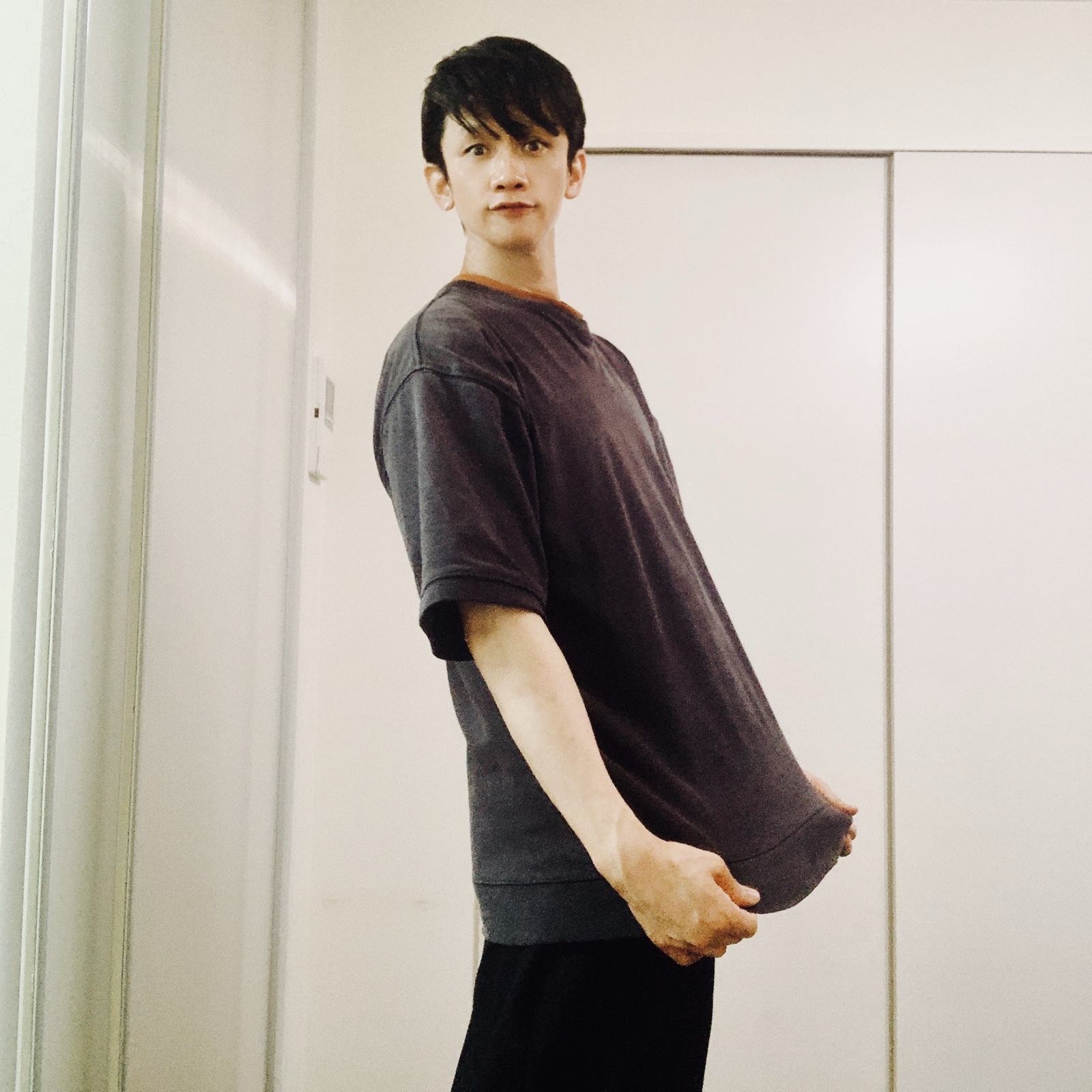 ムーンテッド(MoonTed)の日記より、グレーのTシャツの裾を引っぱって立つムーンテッド(MoonTed)のセラピストAKI