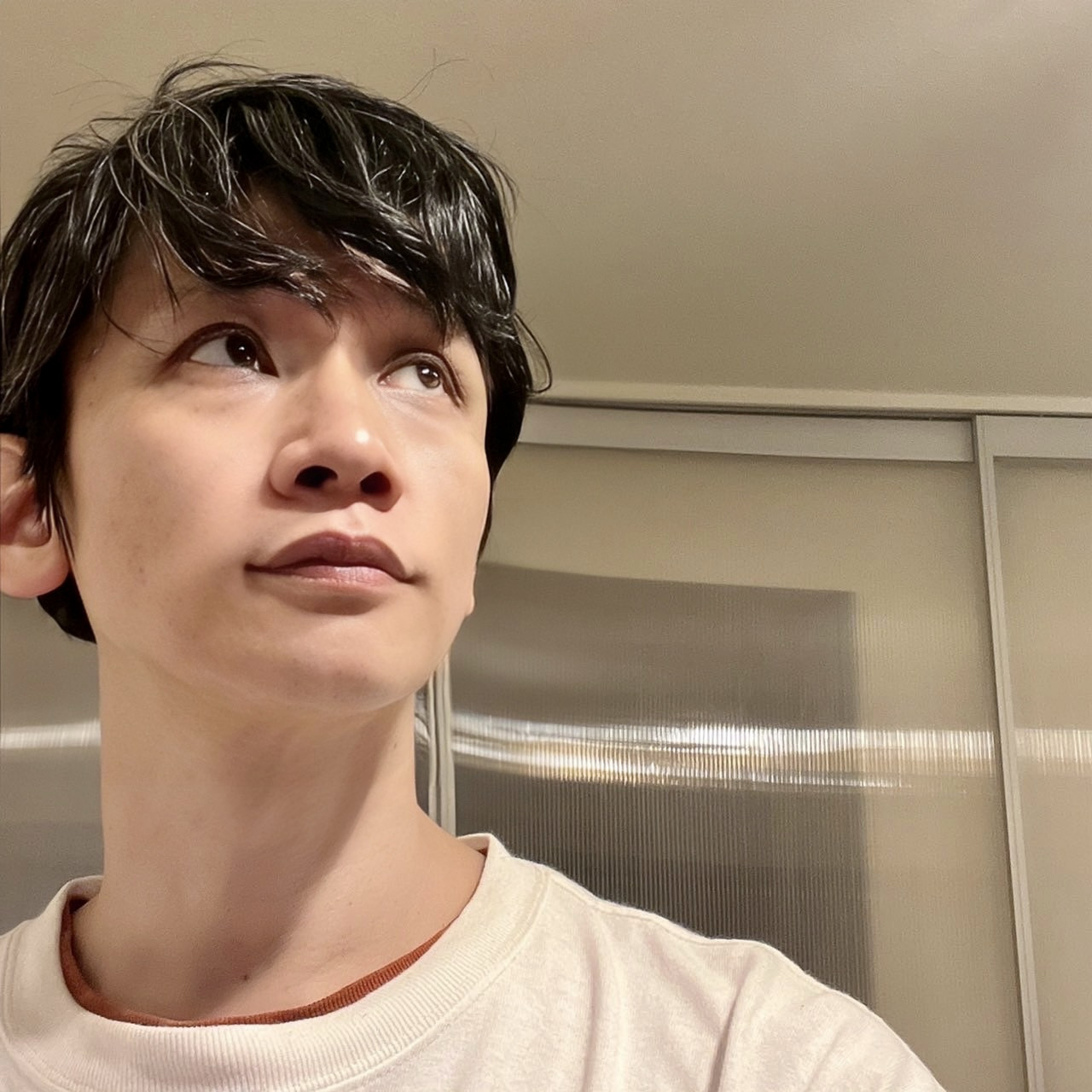ムーンテッド(MoonTed)の日記より、斜め上を見上げるムーンテッド(MoonTed)のセラピストAKI。ベージュのスウェット姿