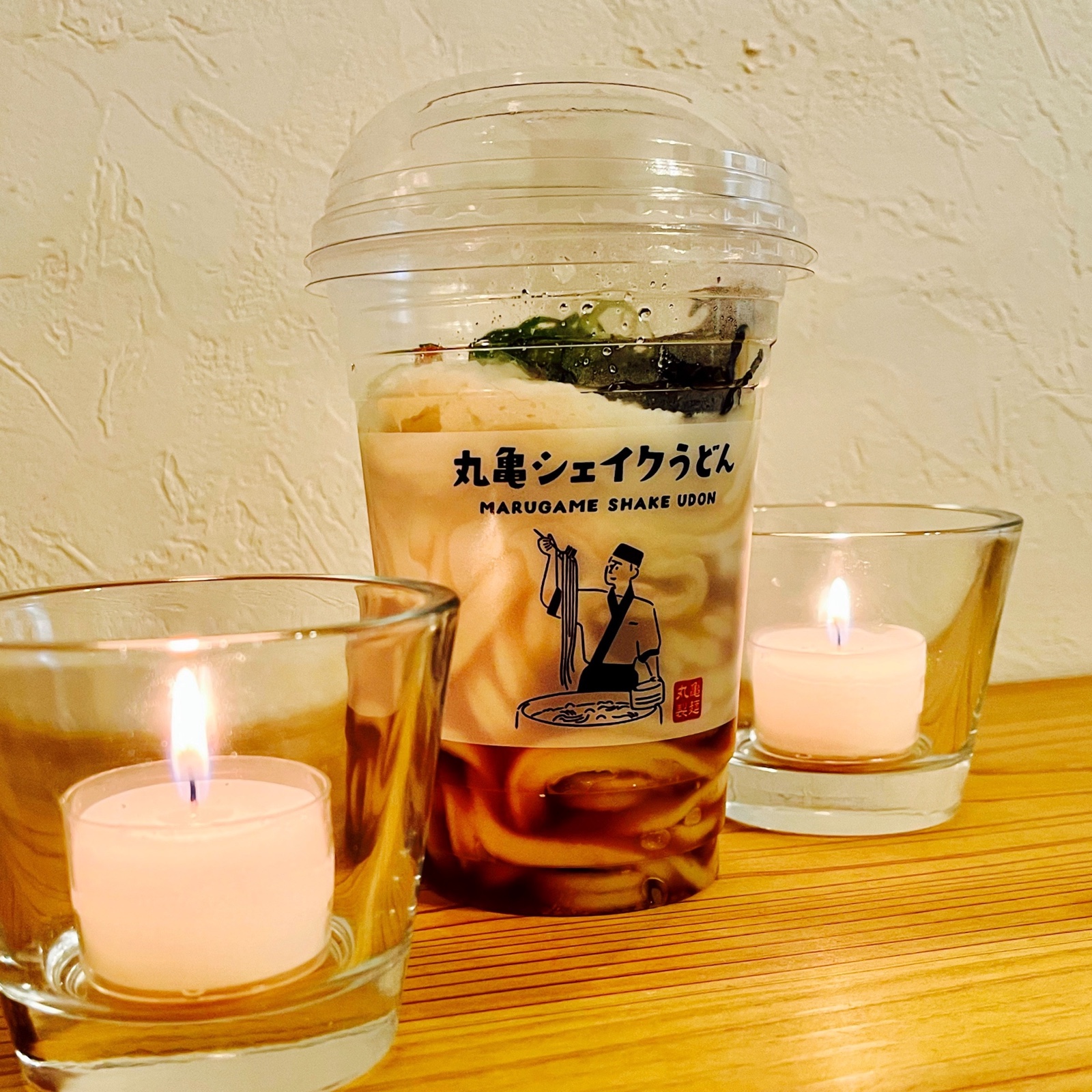 ムーンテッド（MoonTed）の日記より、丸亀製麺の「丸亀シェイクうどん」のカップ。両側にキャンドル