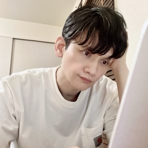 MoonTed Diary: Therapist AKI in a white T-shirt, chin in hand, looking at a laptop screen