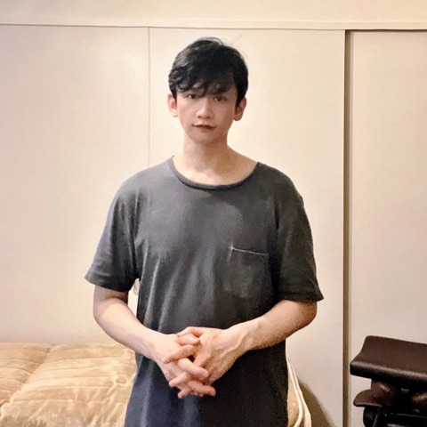 ムーンテッド（MoonTed）の日記より、手を組んで立つムーンテッド（MoonTed）のセラピストAKI。着古したグレーのTシャツ姿