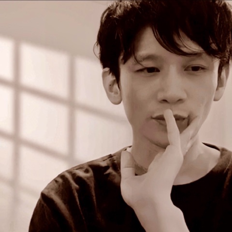 MoonTed Diary: Therapist AKI with a finger touching the lips, in a soft sepia-toned photo