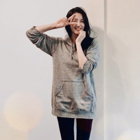 MoonTed Diary: A smiling woman in a gray hoodie making a peace sign by her eye