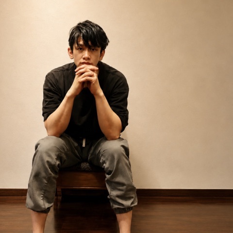 ムーンテッド（MoonTed）の日記より、夜の施術を終え、木のスツールに腰かけて組んだ手にあごをのせるムーンテッド（MoonTed）のセラピストAKI